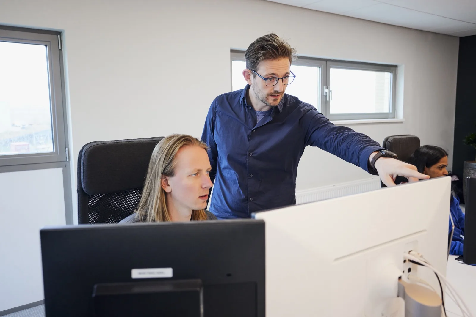 Collega’s werken samen aan een digitale oplossing achter een beeldscherm
