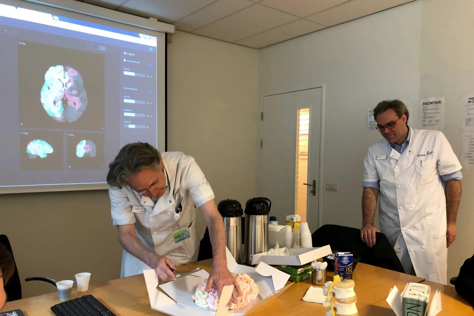 Medisch specialisten bespreken onderzoekssoftware en hersenbeelden tijdens een werksessie