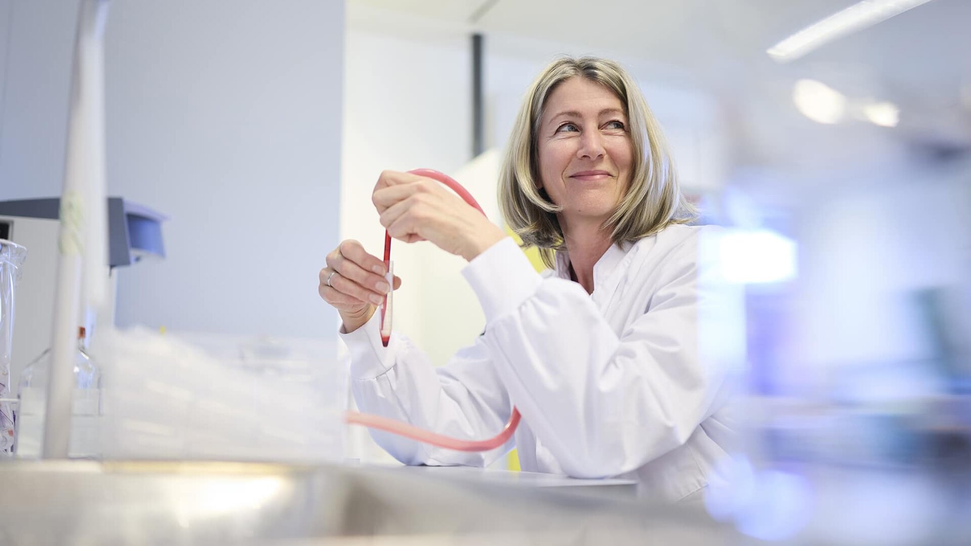 Een glimlachende PurSang-medewerker werkt met laboratoriummateriaal.